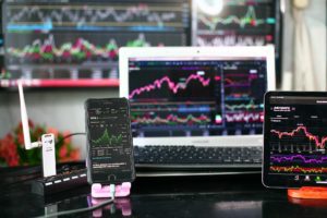 a collection of monitors and phones all displaying crypto exchanges