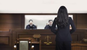 a woman in a suit standing before a judge