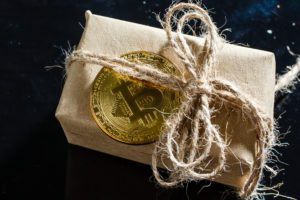package wrapped in brown paper with Bitcoin on top of it
