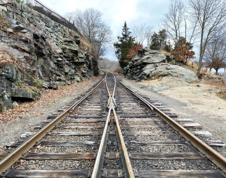 two sets railroad tracks merging into one set of railroad tracks