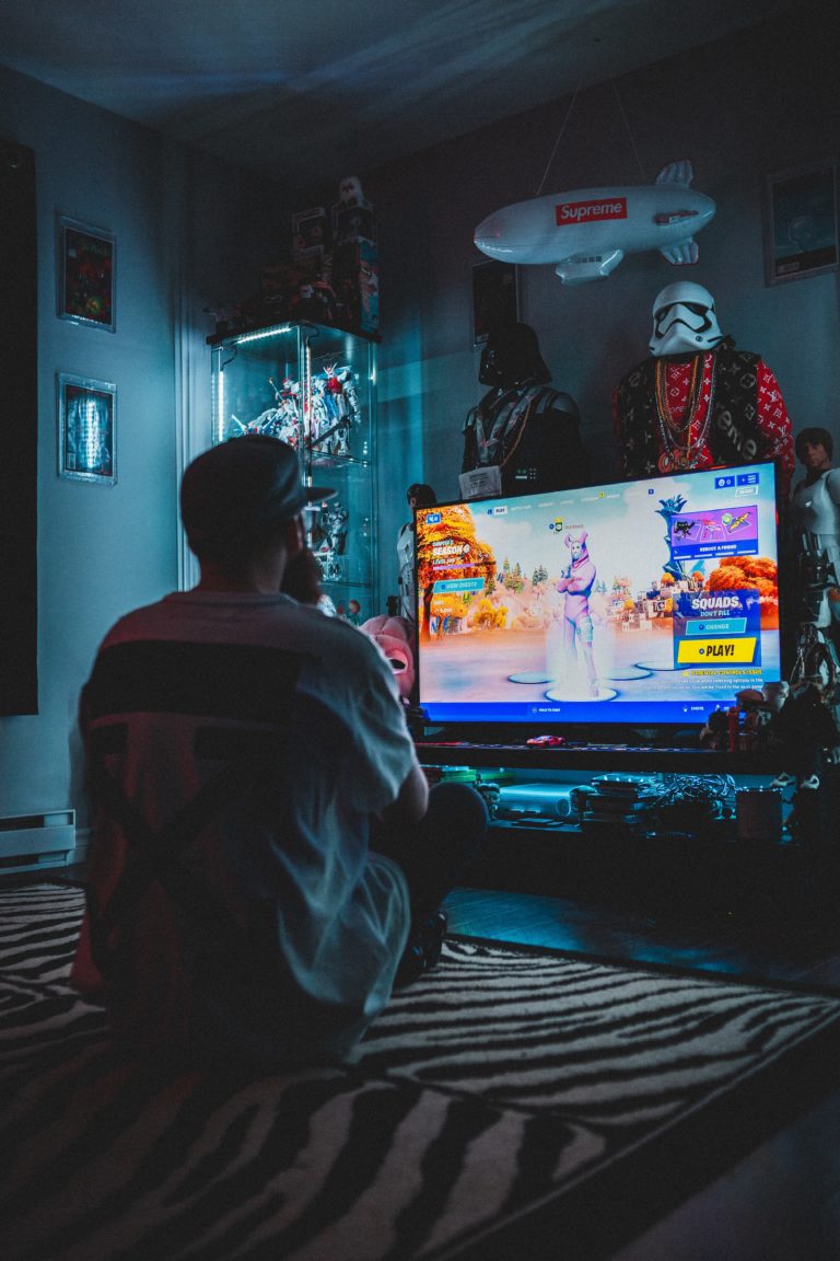 man playing video games in front of tv