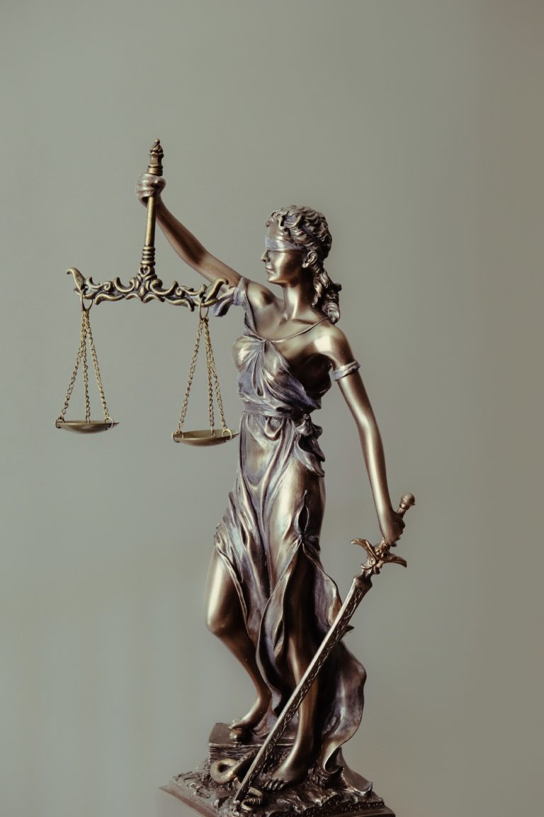 Bronze Lady Justice statue holding scales and sword